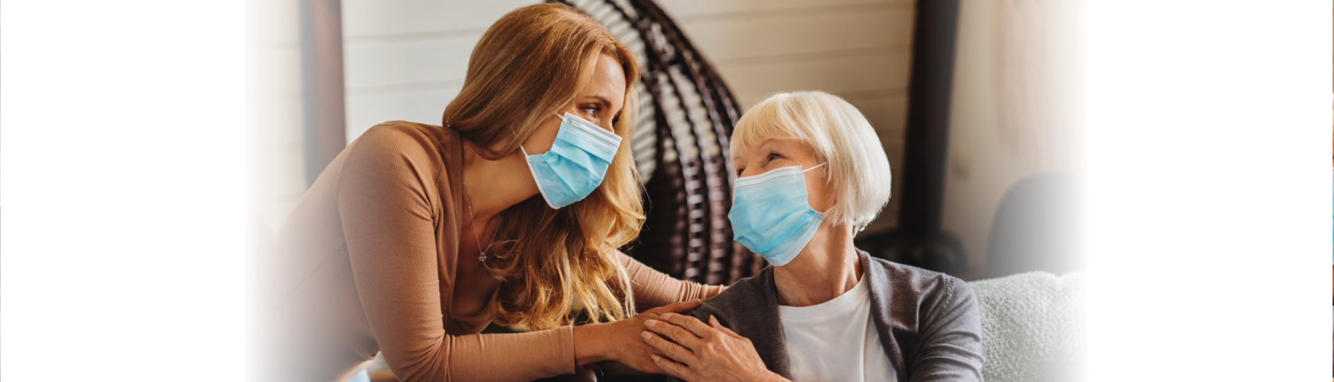 caregiver and elderly woman wearing face mask
